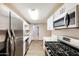 This modern kitchen features a gas range, stainless steel appliances and light counter tops at 3238 W Rose Ln, Phoenix, AZ 85017
