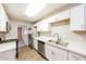 This updated kitchen features white cabinets and stainless steel appliances with light countertops at 3238 W Rose Ln, Phoenix, AZ 85017