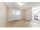 Open-concept living room featuring modern light wood flooring and a view into the kitchen at 3238 W Rose Ln, Phoenix, AZ 85017
