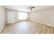 Bright living room with modern light wood flooring, a ceiling fan, and a large window for natural light at 3238 W Rose Ln, Phoenix, AZ 85017