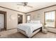 Spacious bedroom with neutral decor, ceiling fan, and a view into the en-suite bathroom at 32650 N 223Rd Dr, Wittmann, AZ 85361