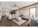 Open-concept living room featuring modern furniture and wood-look flooring, adjoined by kitchen at 32650 N 223Rd Dr, Wittmann, AZ 85361