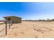 Exterior side view of the home showing the fence line and expansive yard at 32650 N 223Rd Dr, Wittmann, AZ 85361