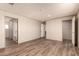 Spacious bedroom with wood-look flooring, closet, and access to a modern ensuite bathroom at 32712 N 223Rd Dr, Wittmann, AZ 85361