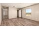 Bright bedroom with wood-look floors and large windows offering views of the surrounding desert landscape at 32712 N 223Rd Dr, Wittmann, AZ 85361