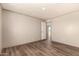 A spacious bedroom with wood-look flooring and a doorway that provides ample natural light at 32712 N 223Rd Dr, Wittmann, AZ 85361