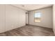 A spacious bedroom featuring a window with views and wood-look flooring throughout at 32712 N 223Rd Dr, Wittmann, AZ 85361