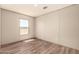 A bright bedroom featuring a window and wood-look floors for warmth and elegance at 32712 N 223Rd Dr, Wittmann, AZ 85361