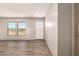 Well-lit entryway with wood-look floors, a bright white front door, and desert views from the windows at 32712 N 223Rd Dr, Wittmann, AZ 85361
