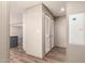 Hallway features wood-look floors leading to storage closets and an opening to another room at 32712 N 223Rd Dr, Wittmann, AZ 85361