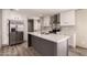 Modern kitchen boasts stainless appliances, a large island, and stylish gray and white finishes at 32712 N 223Rd Dr, Wittmann, AZ 85361