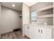 Laundry room with cabinets, shelving, and wood-look floors adds style and functionality at 32712 N 223Rd Dr, Wittmann, AZ 85361