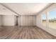 Open living space with wood-look flooring, large windows, and a decorative wall panel for added style at 32712 N 223Rd Dr, Wittmann, AZ 85361