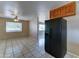 Bright kitchen view showcasing a black refrigerator, tile flooring, and traditional cabinetry with an adjacent dining area at 42 S Vineyard --, Mesa, AZ 85210