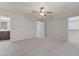 Spacious bedroom with neutral carpet, a ceiling fan, and access to ensuite bathroom and walk-in closet at 5060 S Clancy --, Mesa, AZ 85212