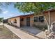 Inviting single-story home with brick accents and an arched entryway, framed by a mature tree and walkway at 6739 N 16Th St # 17, Phoenix, AZ 85016
