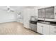 Kitchen with stainless steel microwave, dishwasher, white cabinets, and views to a bright living space at 6739 N 16Th St # 17, Phoenix, AZ 85016