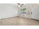 Bright living room featuring wood-look flooring, ceiling fan, and decorative brick wall with a large window at 6739 N 16Th St # 17, Phoenix, AZ 85016