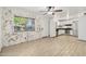 Open concept living area featuring wood-look flooring, brick accent wall, and modern kitchen in the background at 6739 N 16Th St # 17, Phoenix, AZ 85016