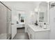 Bright bathroom with double vanity, walk-in shower, white cabinets, quartz countertop, and modern fixtures at 7435 S 76Th Dr, Laveen, AZ 85339
