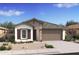 Charming one-story home featuring stone accents, a two-car garage, and desert landscaping at 7435 S 76Th Dr, Laveen, AZ 85339