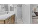 Bright bathroom featuring wood cabinets, double mirrors and a seamless glass shower at 7777 E Main St # 215, Scottsdale, AZ 85251