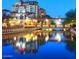 Scenic night view of waterfront property with building reflections and pedestrian bridge with decorative lighting at 7777 E Main St # 215, Scottsdale, AZ 85251