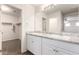 Bathroom featuring double sinks, a walk-in closet, and a large mirror at 840 E Agua Fria Ln, Avondale, AZ 85323