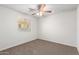 Bedroom with neutral carpet, ceiling fan, and window providing natural light at 840 E Agua Fria Ln, Avondale, AZ 85323