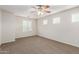 Large bedroom with a ceiling fan, carpet flooring and three windows for natural light at 840 E Agua Fria Ln, Avondale, AZ 85323