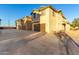 Exterior shot of tan townhomes with garages and long driveway at 840 E Agua Fria Ln, Avondale, AZ 85323