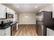 Kitchen with stainless steel appliances, and wood-look flooring leading to dining area at 915 E Commonwealth Pl, Chandler, AZ 85225