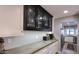 Hallway featuring stylish black cabinets, white cabinets, and countertops, with a view into the kitchen at 943 E Kortsen Rd # 10, Casa Grande, AZ 85122
