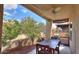 Outdoor patio with wood table, chairs, ceiling fan, and desert landscaping at 943 E Kortsen Rd # 10, Casa Grande, AZ 85122