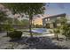 Beautiful backyard with a covered pool and lush landscaping, framed by a tree, creating a private and serene setting at 9805 W Caron Dr, Peoria, AZ 85345