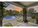 Beautiful backyard view from the covered patio with outdoor living and dining area, pool, and beautiful landscaping at 9805 W Caron Dr, Peoria, AZ 85345