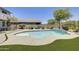 Backyard featuring a freeform pool, artificial turf, patio, and desert landscaping at 9805 W Caron Dr, Peoria, AZ 85345