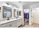 Bathroom with double vanity, granite countertop, and walk-in closet with custom shelving at 9805 W Caron Dr, Peoria, AZ 85345