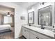 Bathroom with double vanity, granite countertop, walk-in shower and view to the bedroom at 9805 W Caron Dr, Peoria, AZ 85345