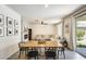 Bright dining area featuring a wood table, black chairs, with a modern fireplace and an airy sectional couch at 9805 W Caron Dr, Peoria, AZ 85345