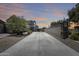 An extra-long driveway leads to a lovely home with beautiful sunset colors in the background at 9805 W Caron Dr, Peoria, AZ 85345