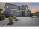 A two-story home with a three-car garage, desert landscaping, and a covered front porch at 9805 W Caron Dr, Peoria, AZ 85345