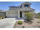 Charming two-story home featuring a tile roof, desert landscaping, and an attached two-car garage at 9805 W Caron Dr, Peoria, AZ 85345