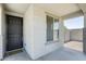 Side view of the front entrance featuring a dark wood door and window with neutral colored stucco at 9805 W Caron Dr, Peoria, AZ 85345