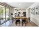 Charming dining area with black chairs and a table, leading into a well-lit kitchen with white cabinets at 9805 W Caron Dr, Peoria, AZ 85345