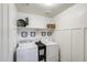 Bright laundry room with white shiplap walls, shelving, washer, and dryer at 9805 W Caron Dr, Peoria, AZ 85345