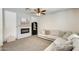 Comfortable living room with a fireplace, a light-colored sectional sofa, and a decorative ceiling fan at 9805 W Caron Dr, Peoria, AZ 85345
