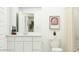 Bright bathroom featuring a white vanity, toilet, framed art and a shower with neutral-toned curtain at 9830 W Pinchot Ave, Phoenix, AZ 85037