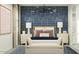 This spacious bedroom has two bedside tables and a blue accent wall with a bold, light-colored geometric pattern at 9839 W Pinchot Ave, Phoenix, AZ 85037