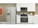 Contemporary kitchen equipped with stainless steel appliances, white cabinets, and modern countertops, ideal for culinary enthusiasts at 9839 W Pinchot Ave, Phoenix, AZ 85037